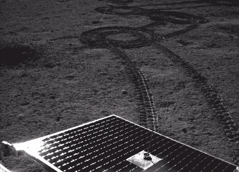 A shot of the lunar surface taken by the Yutu 2 rover, with its solar panels visible.